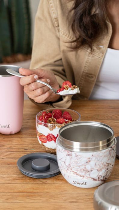A model enjoying a parfait from the inner prep bowl, with the sturdy stainless steel outer bowl close by.
