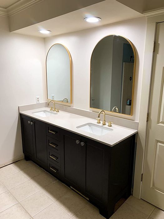 A photo shared by a reviewer showing two elegant arched mirrors with gold edges mounted above a double-sink vanity.