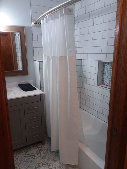 A photo shared by a reviewer depicting a white shower curtain in a tastefully adorned bathroom setting.