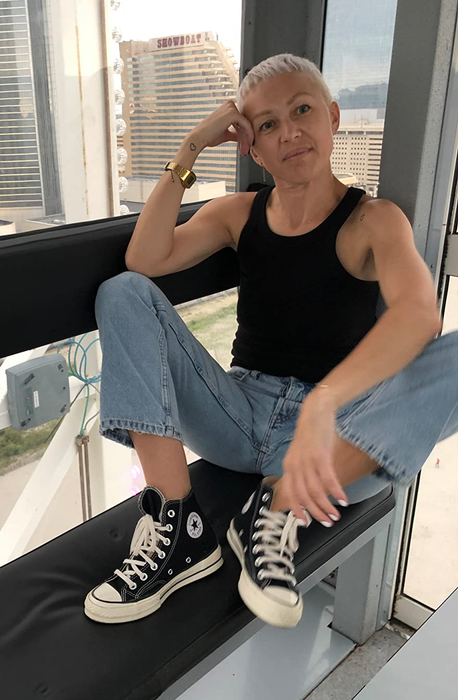A reviewer showcasing the classic black Converse sneakers