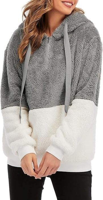 A person sporting a snug two-toned fuzzy hoodie complete with a hood and drawstrings