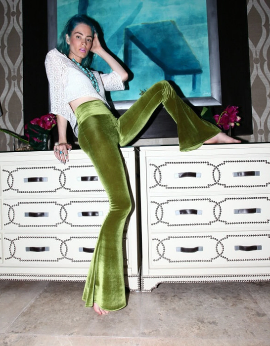 A model flaunting green velvet bell-bottom pants
