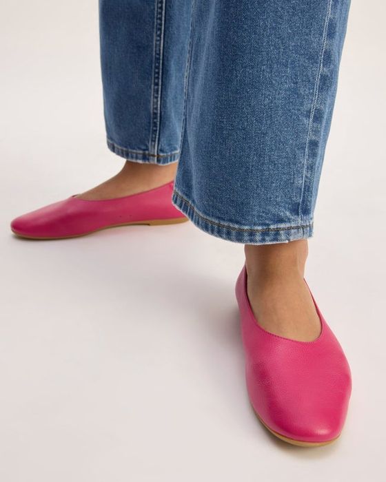 A model showcasing vibrant hot pink flats