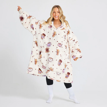 A model dressed in a plush oversized hoodie featuring a charming coffee and donut design, paired with black leggings and white socks
