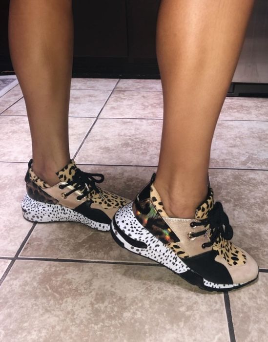 a reviewer showcasing the sneakers, highlighting the vibrant mix of colors and patterns