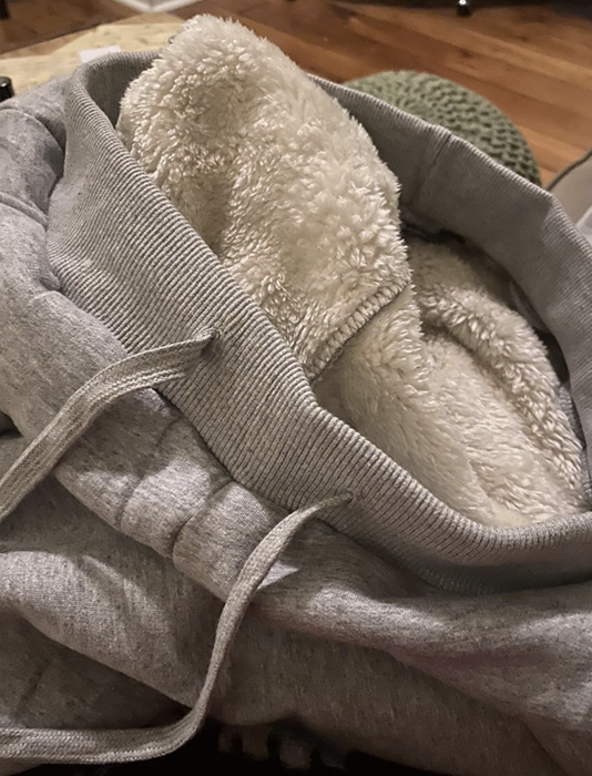 A reviewer showcasing the fleece lining inside the sweatpants