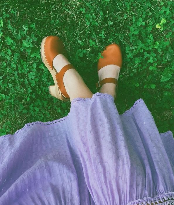 A reviewer showcasing the tan clogs.