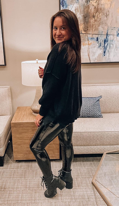 A reviewer modeling the sweater in a sleek black shade
