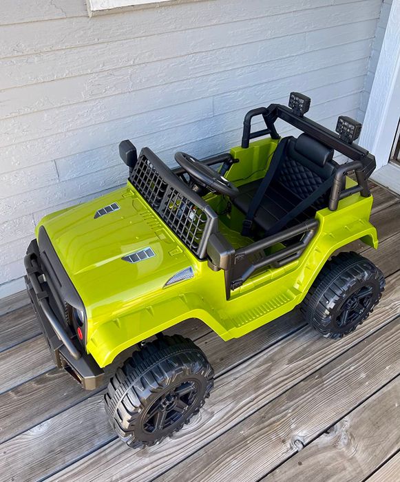 Kids' ride-on toy car parked on a cozy wooden deck