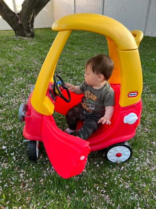 A toddler enjoying a ride in the Little Tikes Cozy Coupe car