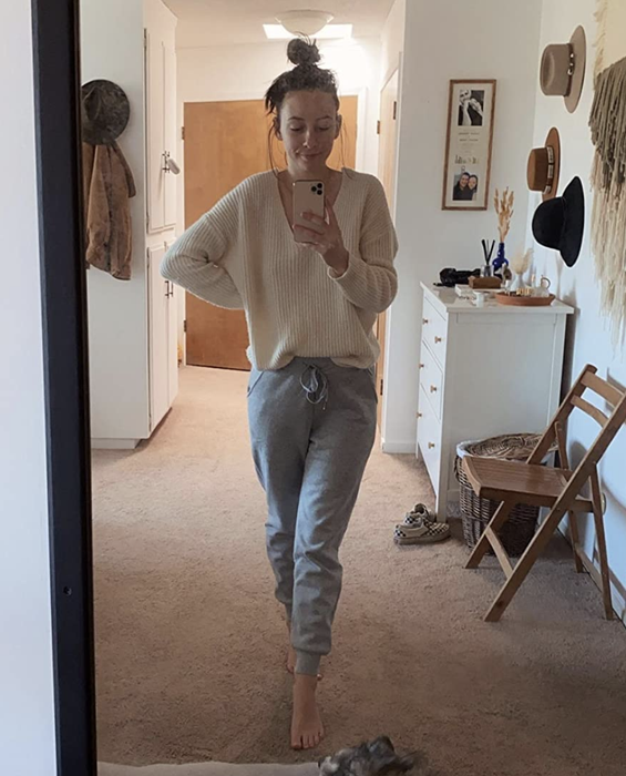 A reviewer snapping a mirror selfie while wearing the gray sweatpants