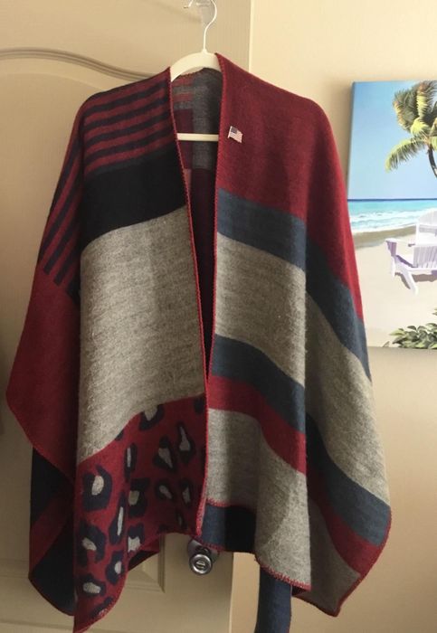 A reviewer's photo of the shawl displaying a mix of vibrant prints, neatly hung on a hanger