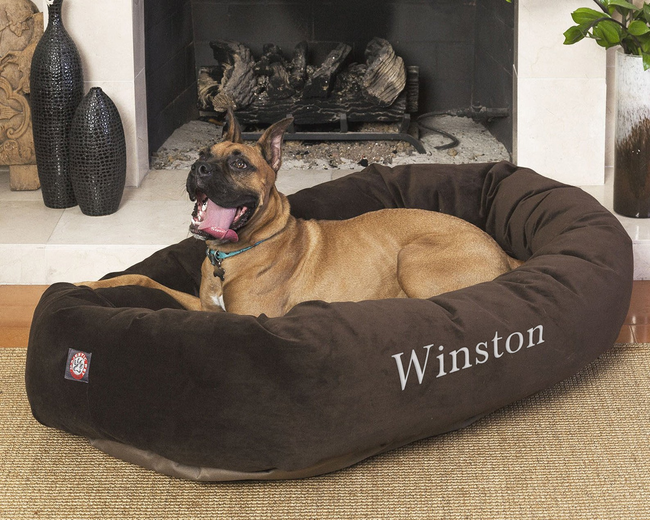 A large dog is enjoying a relaxing moment on a custom-embroidered pet bed.