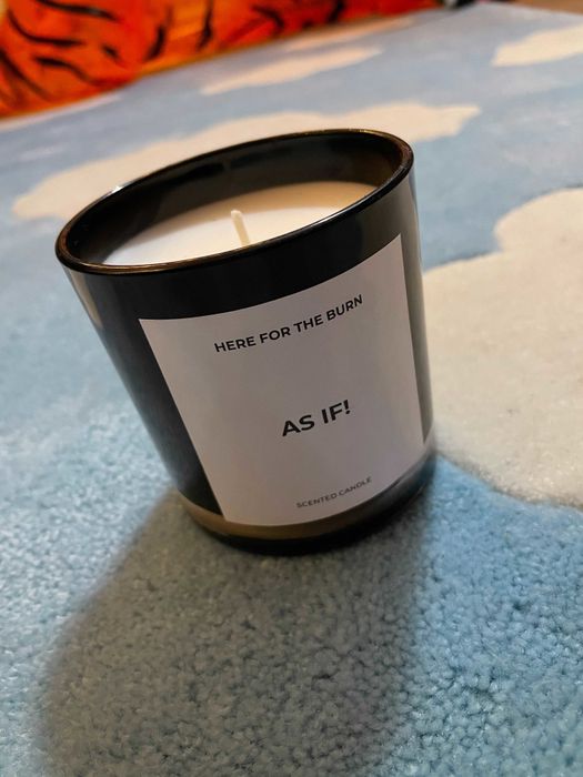 a sleek black candle with white wax, featuring a label that boldly states 'as if!'