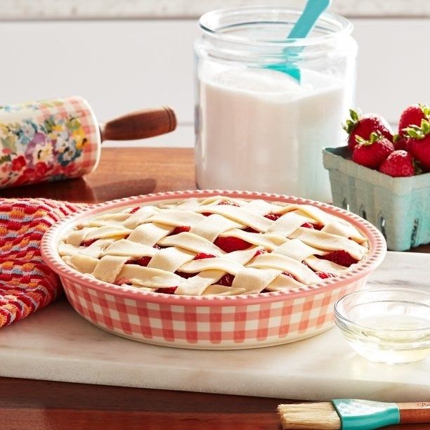 The plaid dish containing an unbaked fruit pie.