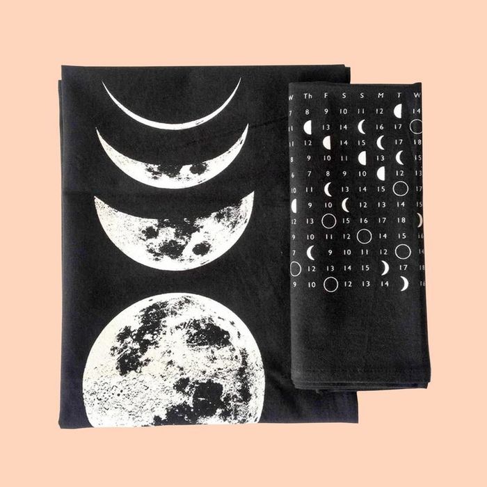 black towels, one displaying a moon calendar and the other showcasing a detailed illustration of moon phases