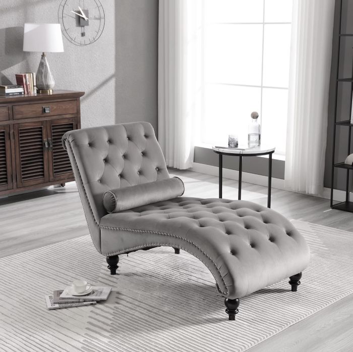 The plush grey velvet lounge chair in the cozy living room setting.
