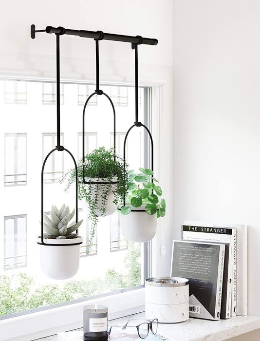 three white planters supported by a sleek black bar