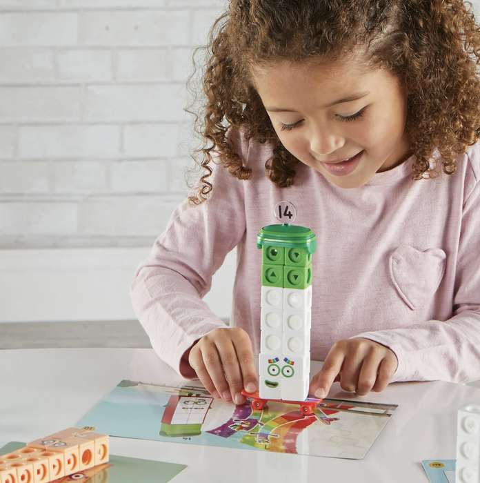 A child having fun stacking building blocks to create a tower on a game board