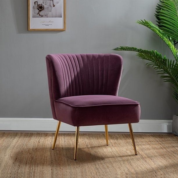 A luxurious purple velvet chair with stylish gold legs.