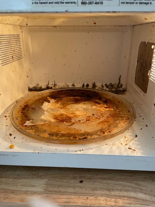 A photo of a microwave covered with grime and food remnants