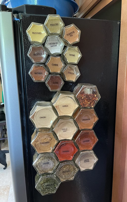The magnetic spice jars, both small and large, attached to the side of a reviewer's fridge