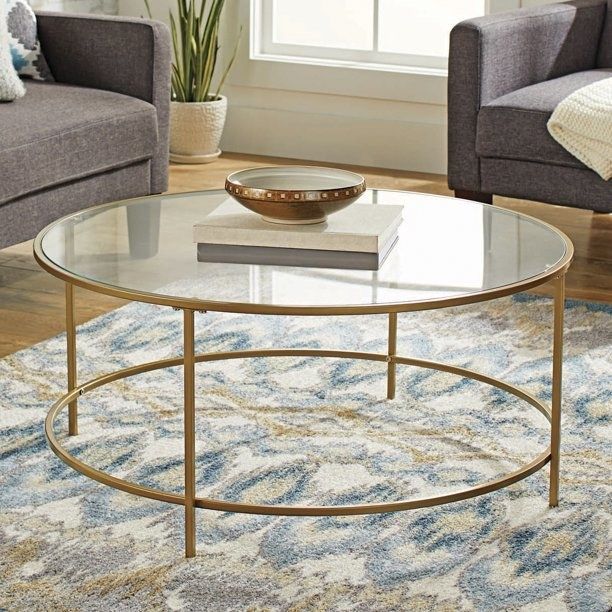 The circular table with a stack of books and a decorative bowl on top.