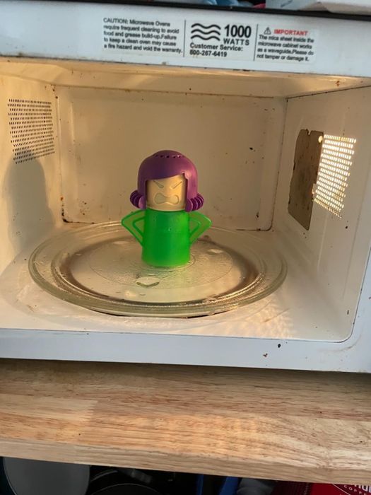 The same microwave looking much cleaner, with the Angry Mama cleaner sitting inside