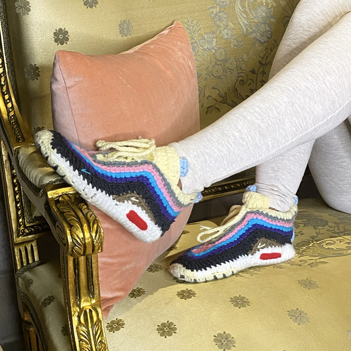 a model showcases knit slippers designed to resemble sneakers