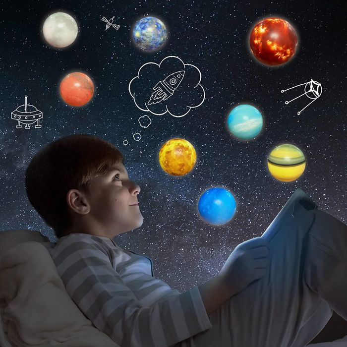 A child in pajamas stares at a tablet under a starry sky, imagining planets and a rocket soaring in a thought bubble.