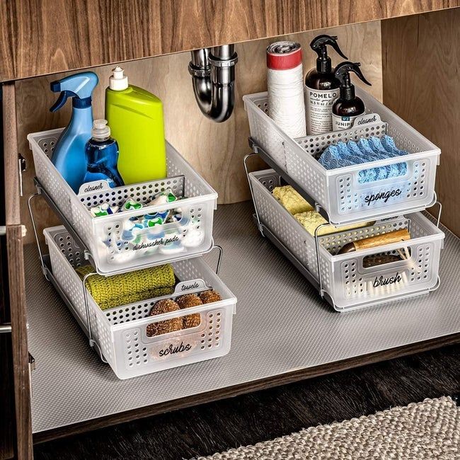 Baskets placed under the sink to organize a variety of cleaning supplies.