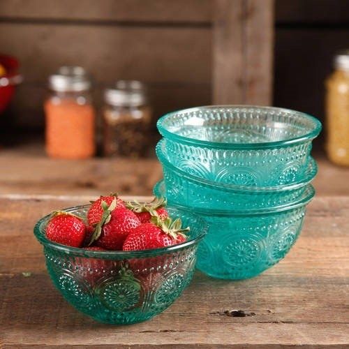 The four teal glass bowls, with three stacked and one holding ripe strawberries.