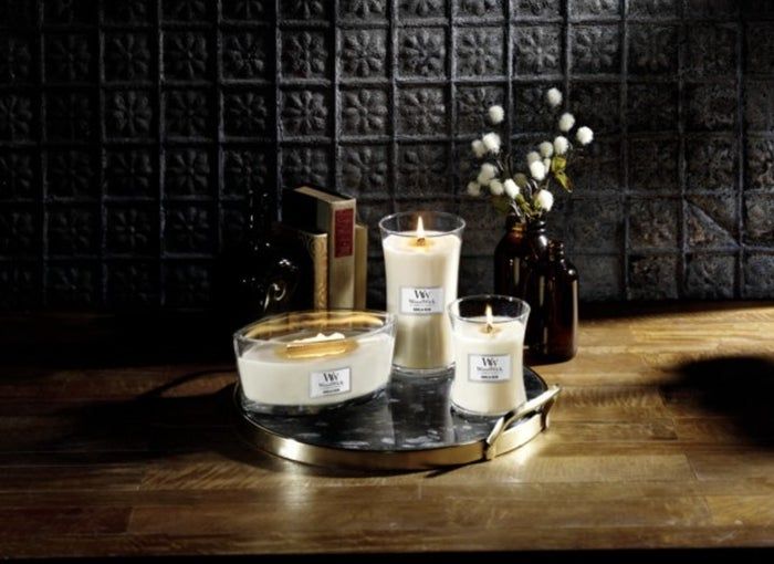 Three different sizes of the lit candle placed on a vanity tray.