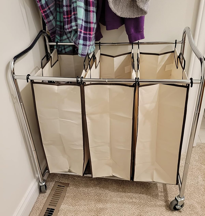 A laundry sorter cart with three spacious compartments to keep your clothes organized.