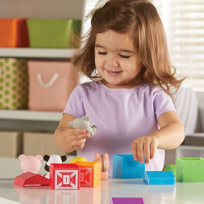 A young child enjoying a colorful set of toy blocks in a playful room.