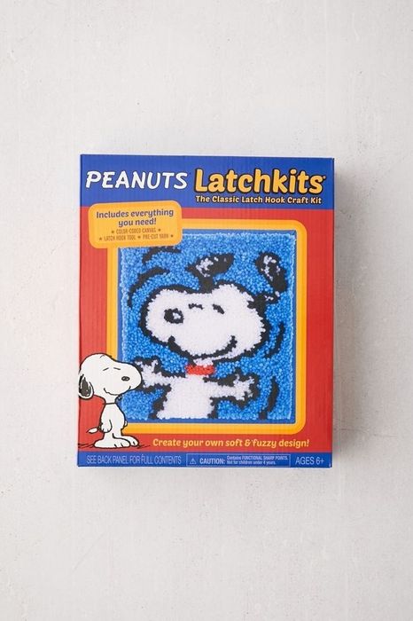 a box labeled peanut latchkits, featuring a small rug with Snoopy set against a blue backdrop
