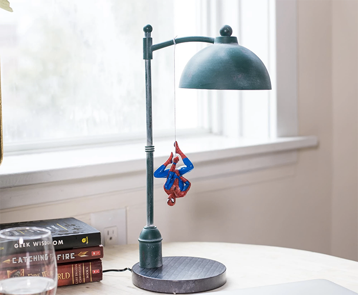 a lamp designed like a city streetlight with Spider-Man hanging from it