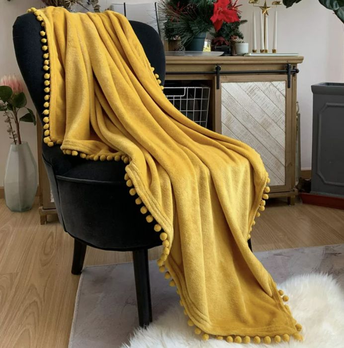 The cheerful yellow blanket draped over an accent chair.
