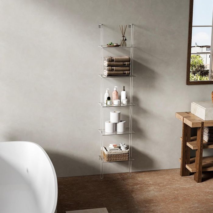 A freestanding bathroom shelf stocked with toiletries and towels