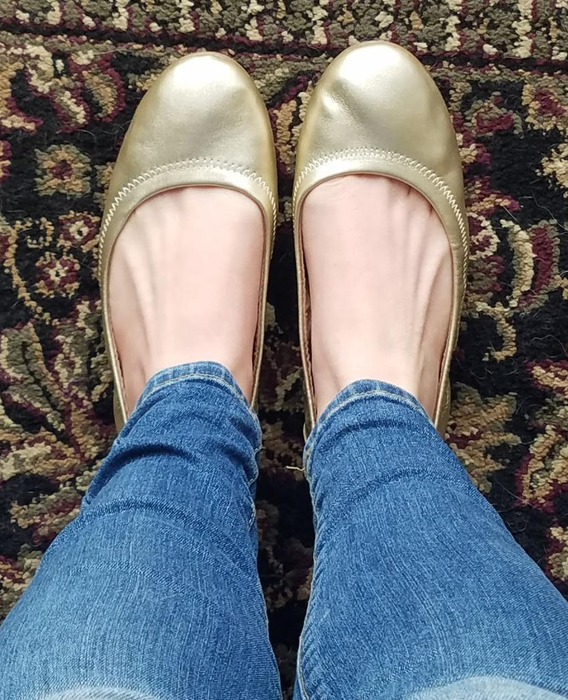 reviewer wearing gold ballet flats