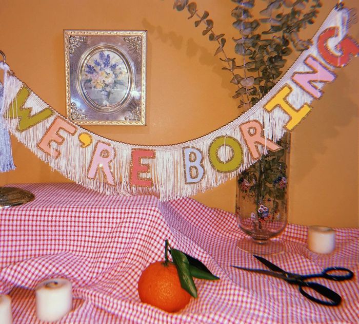 A sparkling tassel banner that reads 'we're boring'.
