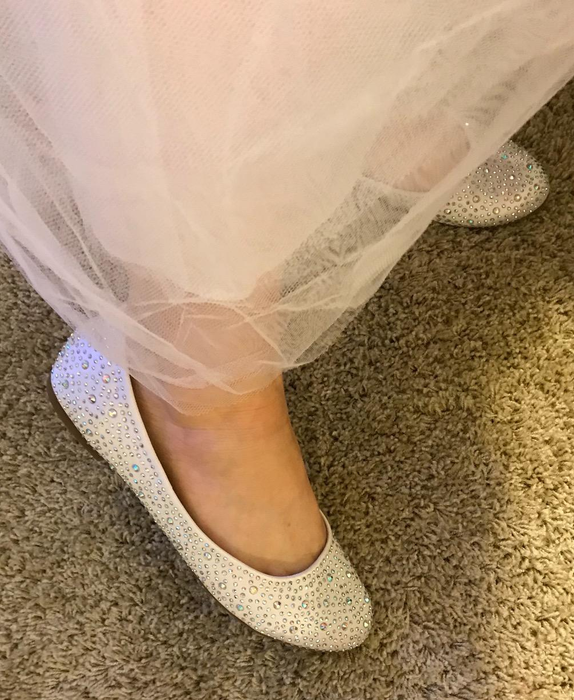 reviewer's foot wearing the white flat shoes