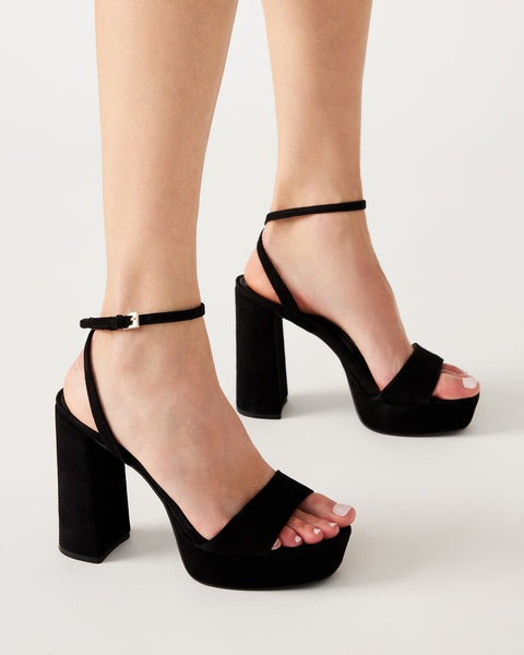 model wearing black platform sandals with a chunky heel and ankle strap
