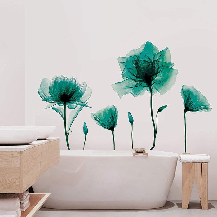 A white bathroom featuring large flower decals behind the bathtub, creating a striking visual effect.