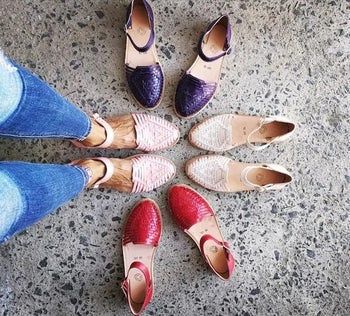 A model shows off pink Huarache sandals, surrounded by an array of colorful sandals.