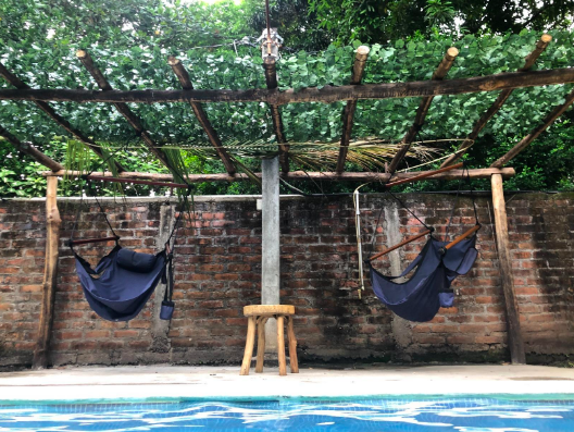 Faux ivy vines draped across a simple wooden frame to create a charming poolside awning.