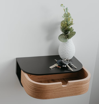 A sleek wooden organizer with a drawer, holding a vase of greenery and keys on top. Perfect for enhancing home decor.