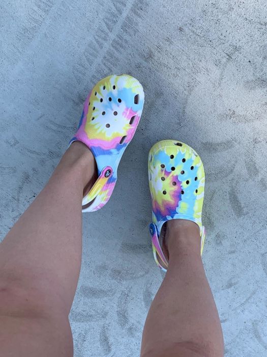 A reviewer shows off their pink, yellow, and blue tie-dye Crocs.