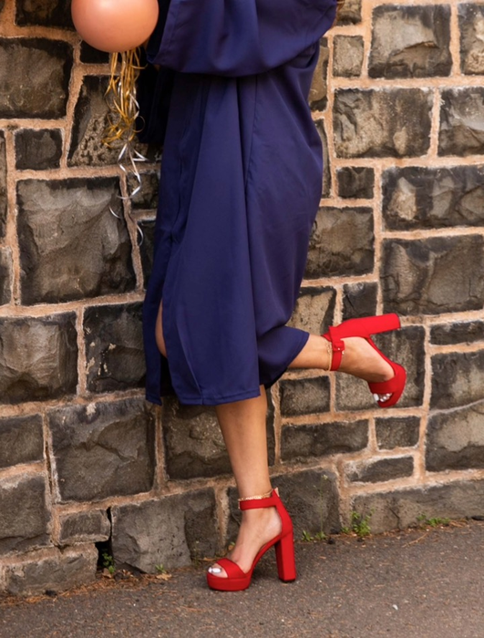 A reviewer is seen wearing red heels.
