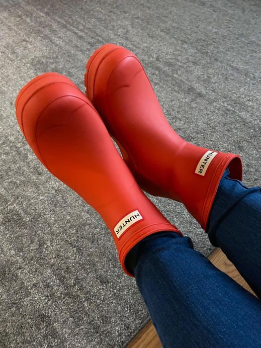 A reviewer styling orange short Hunter boots